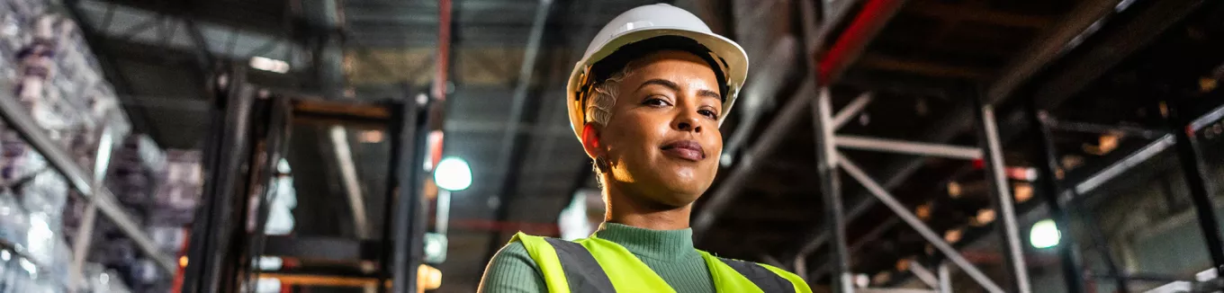 colaboradora em armazém utilizando EPI.