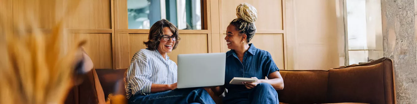 Foto mostra duas mulheres conversando no escritório