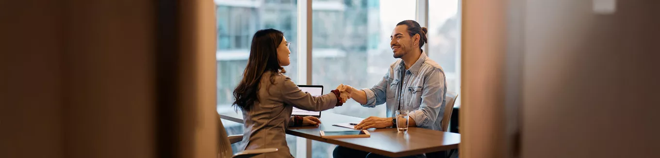 Foto mostra duas pessoas fazendo uma reunião no escritório