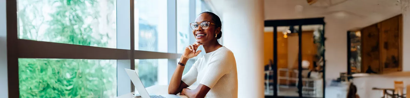 Foto mostra uma mulher animada no seu local de trabalho
