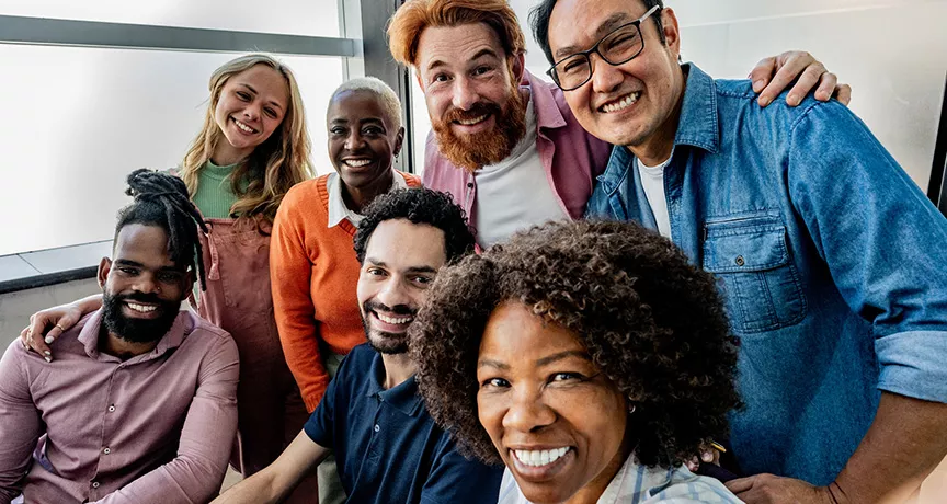equipe de trabalho diversa sorrindo para selfie.