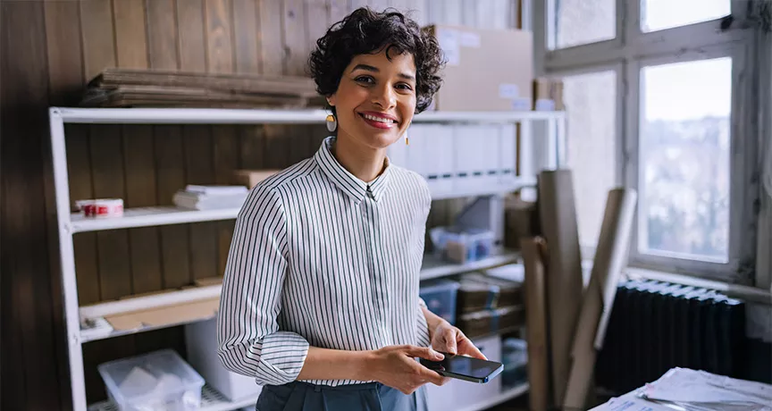 mulher sorrindo em frente a seu empreendimento.